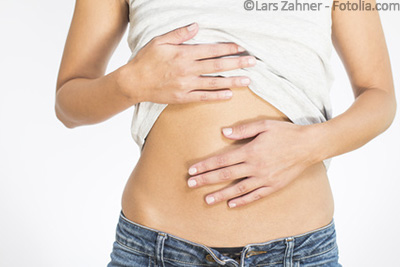 Junge Frau, die den Bauch krazt