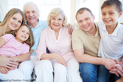 Drei Generationen, die fröhlich beisammen sitzen