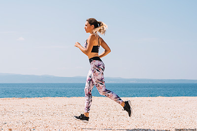 Junge Frau, die am Strand joggt