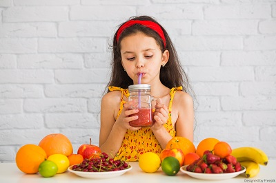 Junges Mädchen mit fruchtigen Smoothies und Obst.