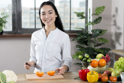 Junge Frau beim schneiden einer Orange.